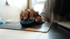 The right hand of a man is holding a computer mouse, camera is placed real close, seeing the man's fingers move gently over the mouse's buttons. a 4K video clip.