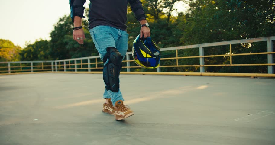Close-up shot of a biker rides with a motorcyclist helmet along motorcycles in a motorcycle school. Motorcycle training ground