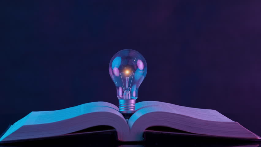Glowing light bulb and graduation cap with tessel icon above opened book. E-learning online, education congratulation, graduation ceremony, key to success and knowledge learning concept. Royalty-Free Stock Footage #1108286269
