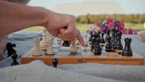 Crop of man and woman lying down on grey rug and playing chess together in public park. Carefree people enjoying leisure activities on fresh air. Concept of strategy and challenging. - Powered by Shutterstock - Get 15% off with code: PIKWIZARD15