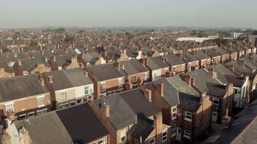 4K aerial drone footage above the rooftops of back to back terraced houses tightly packed together on a council estate in the North of England during the UK Government's levelling up programme Royalty-Free Stock Footage #1108292019