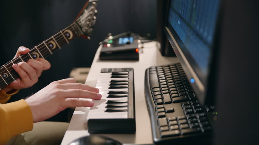 Music production studio. Unrecognisable man recording electro guitar piano music. Producer man working in the recording studio with computer and mixer creating music in sound recording studio. Royalty-Free Stock Footage #1108292555