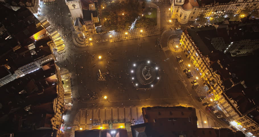 Prague Czechia Aerial v38 hyper-lapse birds eye view of buzzing old town square, tilt up reverse flyover church of our lady before tyn capturing night cityscape - Shot with Mavic 3 Cine - October 2022