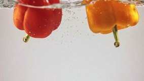 Fresh red and yellow peppers falling into water. Delicious taste of organic vegetables. Paprika, bell peppers. Concept of natural and organic food, nutrition, diet, vitamins. Space for ad - Powered by Shutterstock - Get 15% off with code: PIKWIZARD15