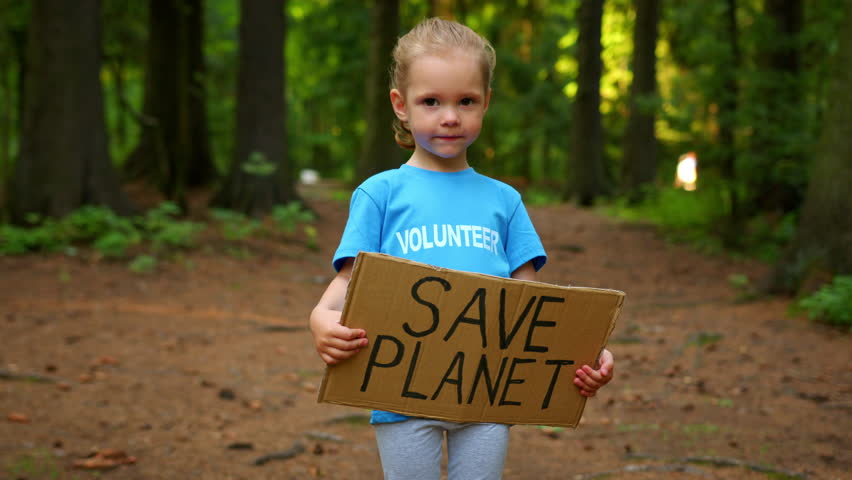 Preschooler girl holding Save Planet cardboard on dense forest background