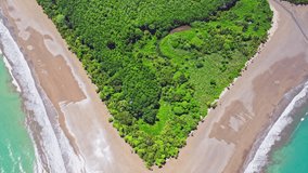 Aerial drone footage revealing a beach shaped like a whale's tail in Ballena Marine National Park, Costa Rica