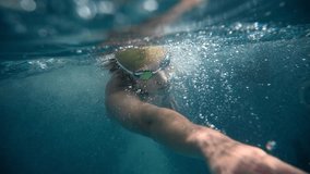 Underwater view of professional swimmer training in swimming pool, 4k 120 fps super slow motion raw video. Triathlete swim in black wetsuit  - Powered by Shutterstock - Get 15% off with code: PIKWIZARD15