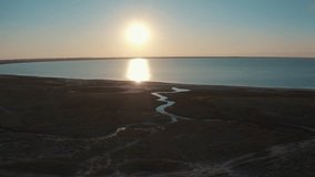 This stock video shows a beautiful sunset over the lake. This video will decorate your projects related to nature, reservoirs, lakes, seas, sunsets, travel.