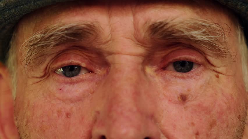 Tired eyes of a senior caucasian man. Close-up of an elderly wrinkled man's eyes. Wise look of an old grandfather. Grandparents day concept. Royalty-Free Stock Footage #1108305909