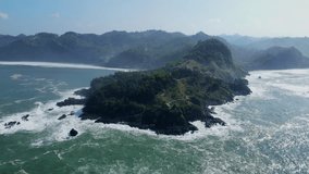 Aerial view of the coral promontory jutting into the open sea. Aerial panoramic view of exotic headland of Menganti Beach, Indonesia - 4K drone shot of Tropical Beach