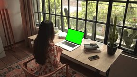Woman Looking at Laptop Computer with Green Screen Chroma Key for Mock Up. Person Working at Video Call Meet and Talking at Creative Lesson. Student in Pretty Office Watching Internet Website Online - Powered by Shutterstock - Get 15% off with code: PIKWIZARD15