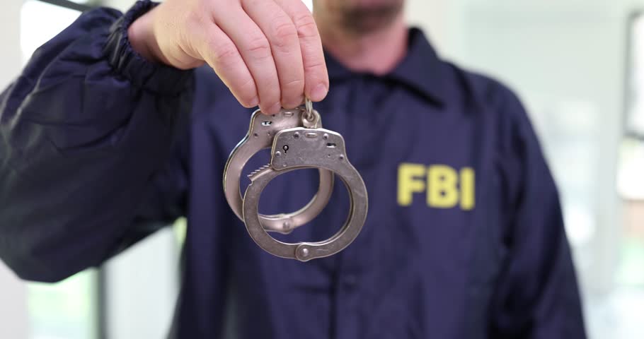Male FBI agent holding handcuffs at police station Royalty-Free Stock Footage #1108315107