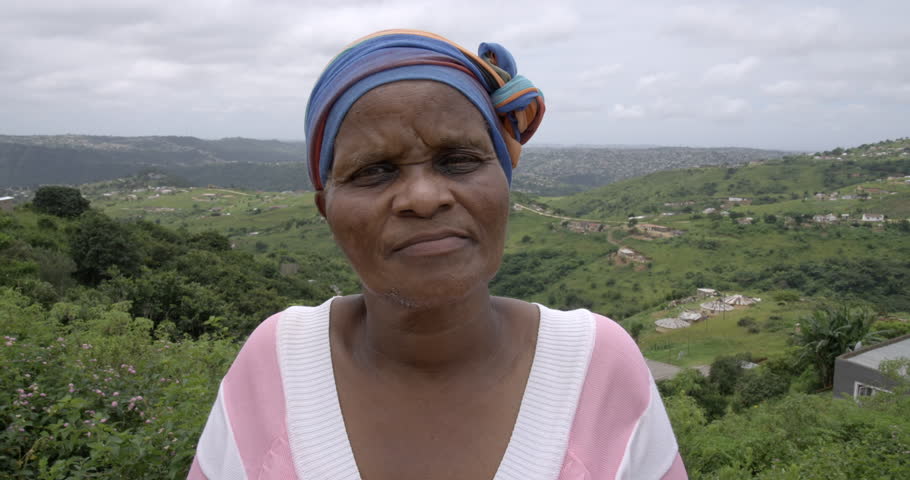 An elderly African woman putting on a KN95 face mask for protection against the COVID-19 virus.
