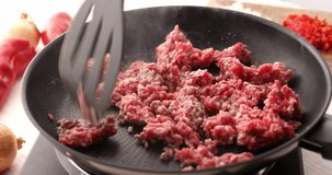 Man frying minced meat in a frying pan stirring with a spatula. Cooking bolognese sauce. Food preparation in the kitchen. A series of footage to visualize the recipe.
