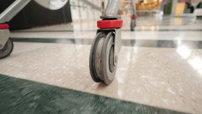 Shopping cart. Low-angle view, focused on wheel of shopping trolley - Powered by Shutterstock - Get 15% off with code: PIKWIZARD15