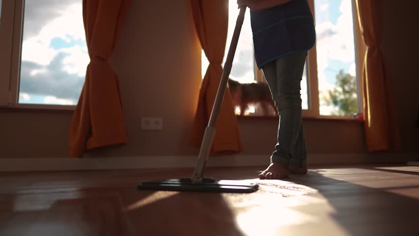 the child baby washed floors. happy family kid dream concept. daughter washed the floors with a mop in the indoors kitchen in an apron helps mom. mom asked the child girl to mop the floors
