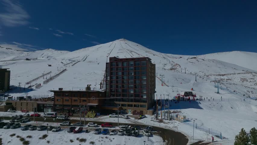 Aerial pull-out shot revealing shot of a large hotel at the base of the El Colorado piste