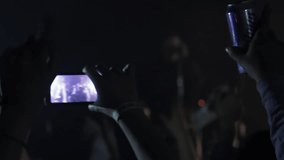 Woman Hands Holding Smartphone While Recording Video of Live Music Concert. Close Up.