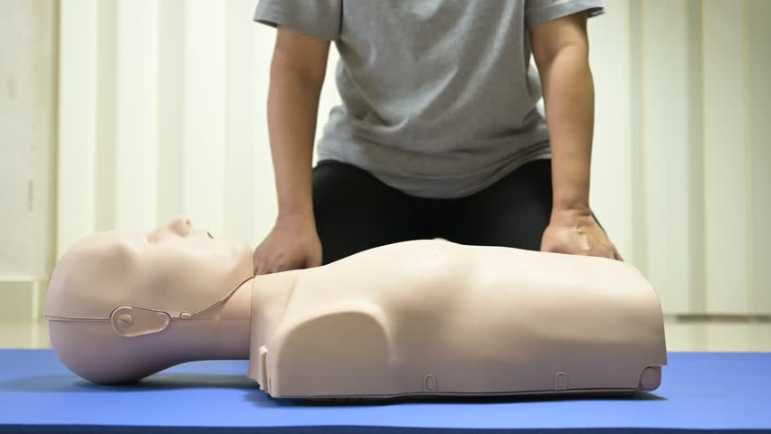 Demonstrating CPR (Cardiopulmonary resuscitation) training medical procedure on CPR doll in the class.Doctor and nurse students are learning how to rescue the patient.First aid for safe life concept. Royalty-Free Stock Footage #1108337435