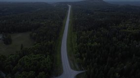 Revealing aerial shot of the highway in the Canadian Rocky Mountains surrounded by forest in summertime. - Powered by Shutterstock - Get 15% off with code: PIKWIZARD15