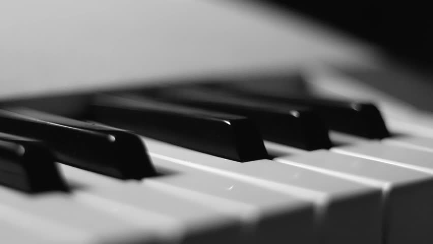 Close-up macro pan of black and white piano keys. Elegant piano keys moving, close up.Tracking backwards shot. Slow motion. Black and white keys. Reflection on piano keys. Music, learn, artistic Royalty-Free Stock Footage #1108343063