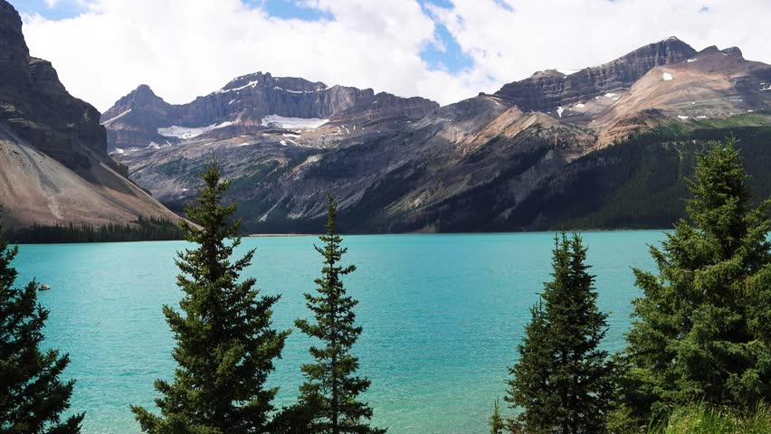Looking out over the bright blue Bow Lake with surrounding mountains and forests in Banff National Park, Alberta, Canada. Glacial lake in the Canadian Rockies. 