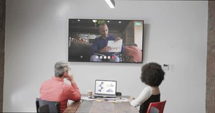 Diverse business people on video call with african american male colleague on screen. Online connections, business and networking concept.