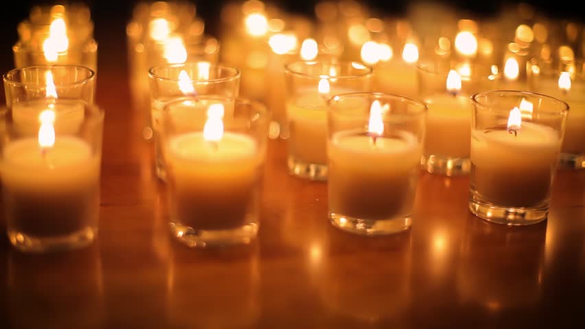 Camera moves past rows of glowing candles in a church or temple. Royalty-Free Stock Footage #1108351897