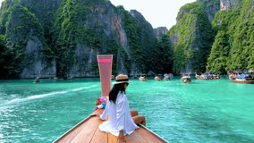Thai women in front of a Longtail boat at Pileh Lagoon with the green emerald ocean at Koh Phi Phi Thailand, - Powered by Shutterstock - Get 15% off with code: PIKWIZARD15