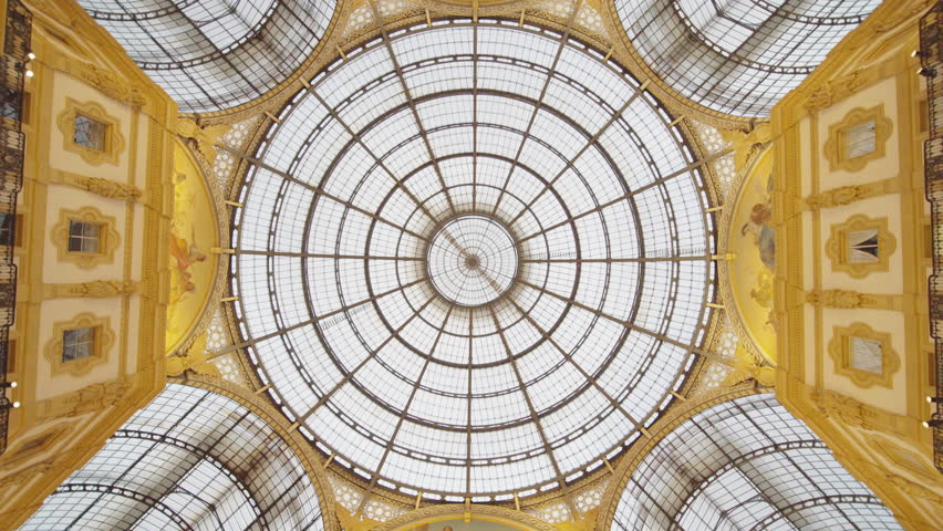 Spinning camera upward shot of Glass Dome in Vittorio Emanuele II, Milan's iconic famous travel shopping arcade where history meets fashion oldest mall in Milano, Lombardy, Italy, Europe. Royalty-Free Stock Footage #1108353831