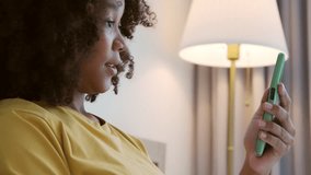 Smiling Black African American Pregnant woman holding showing ultrasound scan photos. Expecting mother having video call with family on smartphone at bed. - Powered by Shutterstock - Get 15% off with code: PIKWIZARD15