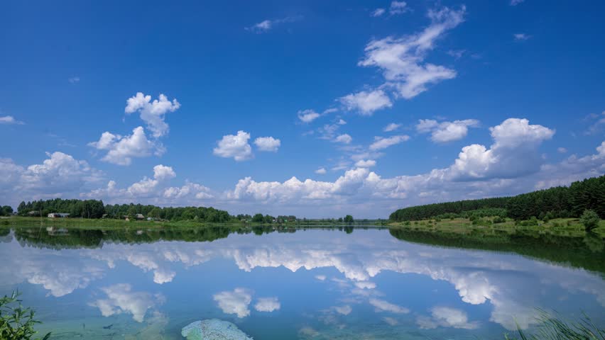 Natural Lake Landscape 4K High Definition Reflection Speeding On Water Level with Forest Background Reflection of Clouds on rippling water. Scenic Relaxing Scenery on Clear Summer Day. video loop Royalty-Free Stock Footage #1108355387