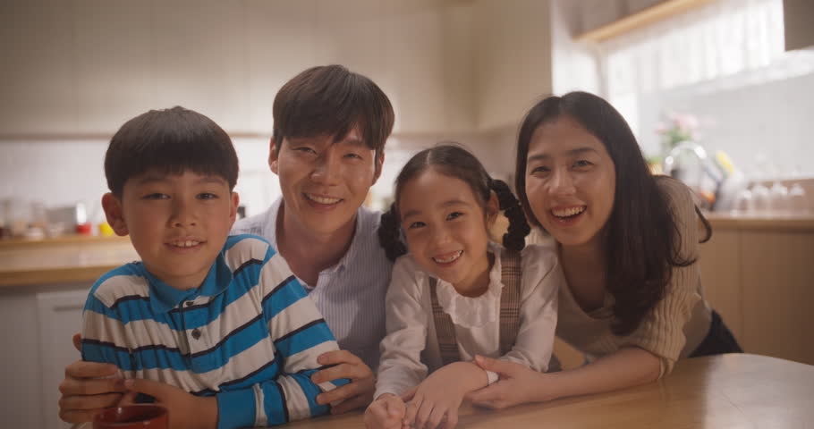 Portrait of Happy Korean Family Looking at Camera and Smiling in their Sunny Apartment. Young Parents and Two Adorable Kids Posing for a Photo, Keeping Memories, Showing Love and Support. Slow Motion Royalty-Free Stock Footage #1108358073