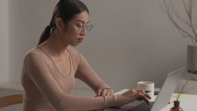 Asian person using laptop computer, sitting in living room in apartment. attractive man is working from home, Online shopping, watching videos or writing emails. 4k