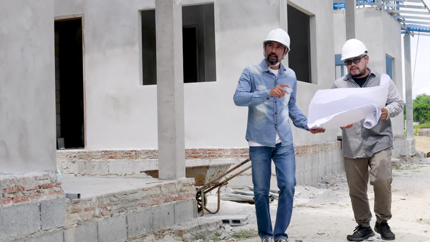 Unrecognizable face architect man with mustache wearing hard hat explaining the inspection to partner foreman at construction site. Asian engineer hold blueprint listen to manager vision or contractor | Shutterstock HD Video #1108360359
