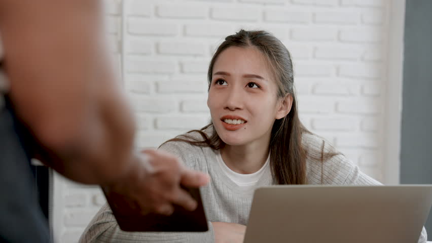 Indian waitress hands tablet to beautiful Asian woman working lunch at cafe and orders food from tablet in hand, use technology to help in restaurant to quickly order food. | Shutterstock HD Video #1108361163
