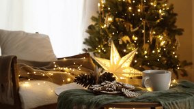 Hands in cozy sweater putting stylish wrapped gift on modern chair on background of festive christmas tree with lights in cozy room. Atmospheric christmas eve footage. Merry Christmas! - Powered by Shutterstock - Get 15% off with code: PIKWIZARD15