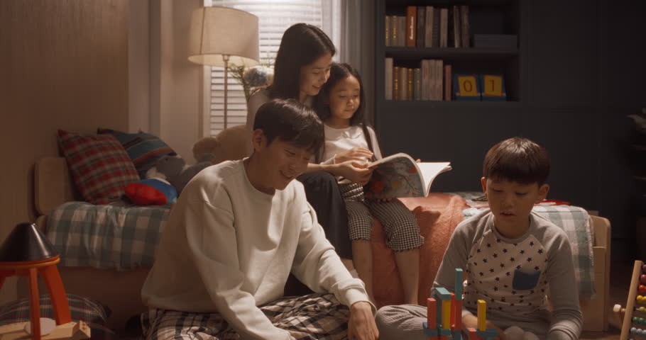 Portrait of a Beautiful Asian Family Posing, Smiling, Looking at Camera. Happy South Korean Parents Playing with Two Children at Home, Brother and Sister are Busy Reading and Constructing Toy Houses