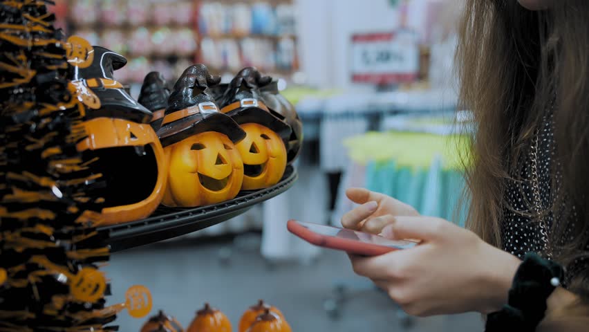 Halloween. Halloween shopping. Halloween accessories. ceramic candle lamps in form of pumpkins in black hats on the shelves in the store. close-up. shop window . preparations for Halloween.  Royalty-Free Stock Footage #1108363921
