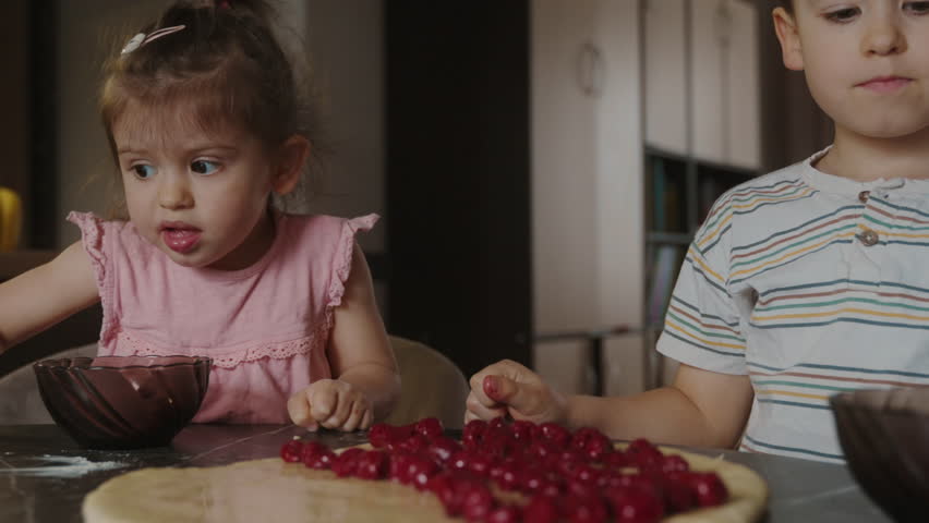 Happy loving family with two kids preparing bakery together. Granny and child are cooking cherry-pies and having fun in the kitchen.