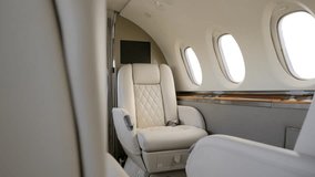 Luxurious passenger cabin of private corporate airplane with cozy white comfortable recliners. Bright salon with round portholes and open access to pilots cockpit - Powered by Shutterstock - Get 15% off with code: PIKWIZARD15