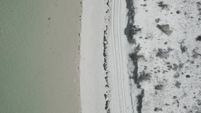 Aerial view captures the sandy shore being gently kissed by the sea in the Alentejo region of Portugal, creating a serene and picturesque coastal scene. - Powered by Shutterstock - Get 15% off with code: PIKWIZARD15