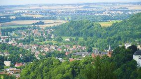 top bird view of a cities and villages around Czech Republic surrounded by nature forests and fields mainly red coloured roofs sunny day a brown castle royal palace pointed towers for high class