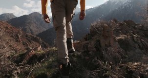Epic camera follow shot of man with backpack climbing up trail on mountain pass. Genuine outdoor lifestyle. Autumn vacation. Overcoming obstacles travel difficulties, perseverance, will, courage