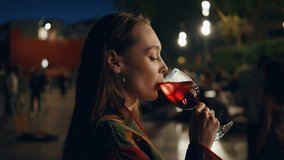 Party woman drinking aperol having fun at night street closeup. Happy carefree girl enjoying town nightlife with alcohol glass. Clubbing lady dancing at evening city celebrating weekend. Urban leisure - Powered by Shutterstock - Get 15% off with code: PIKWIZARD15