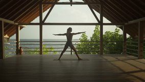Woman leaning into warrior pose in serene wooden cabana, yoga wellness sanctuary - Powered by Shutterstock - Get 15% off with code: PIKWIZARD15