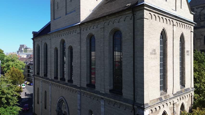 Drone flight along the Basilica of St. Kunibert in Cologne, Germany, in 4k on a bright hot summer day in September 2023