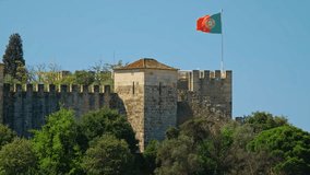 Saint George Castle Castelo de Sao Jorge in Lisboa, Portugal with walking tourists and large Portuguese flag - Powered by Shutterstock - Get 15% off with code: PIKWIZARD15