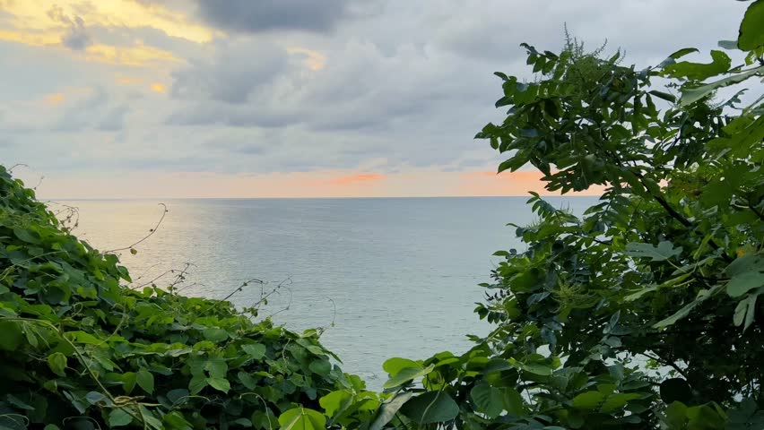 4K video. Horizon line on sea coast. Landscape View of Black Sea, tropical islands, exotic plants, setting sun, evening sky. Georgian resort city of Batumi. Concept of summer holiday, vacation, travel
