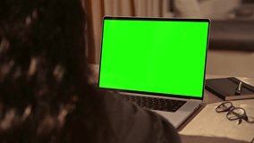 Woman Looking at Laptop Computer with Green Screen Chroma Key for Mock Up. Girl Working Online at Video Call or Creative Lesson Meeting. Student Watching Internet Website or Studying Program Code